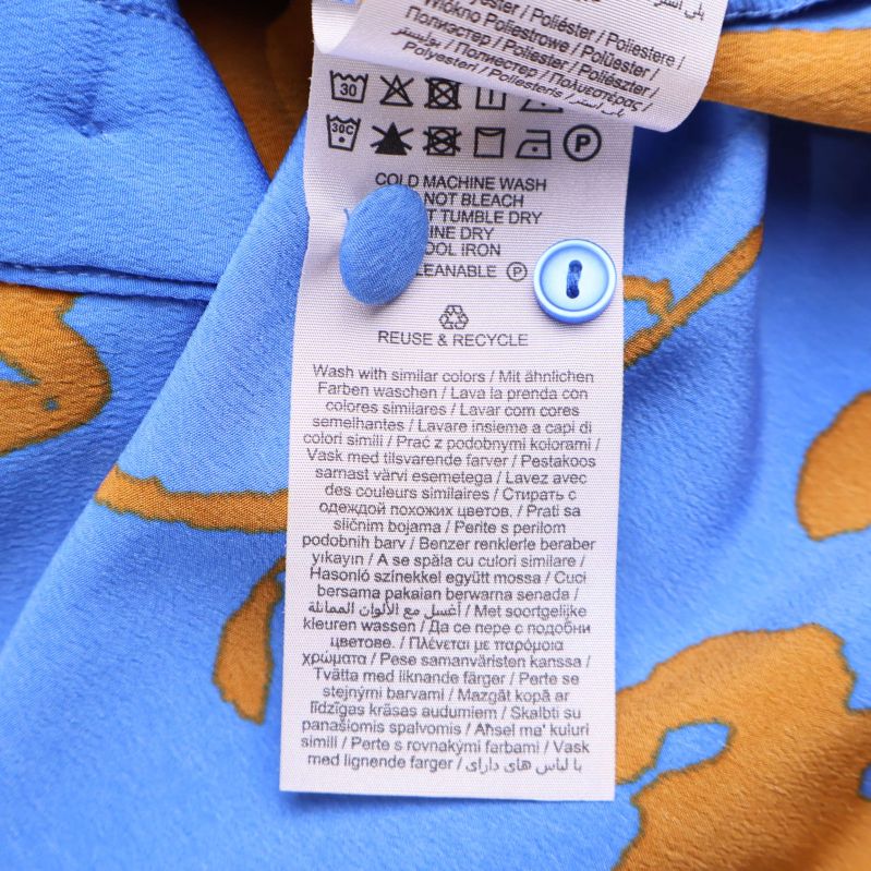 Tvättrådsetikett med materialinformation på skjortan