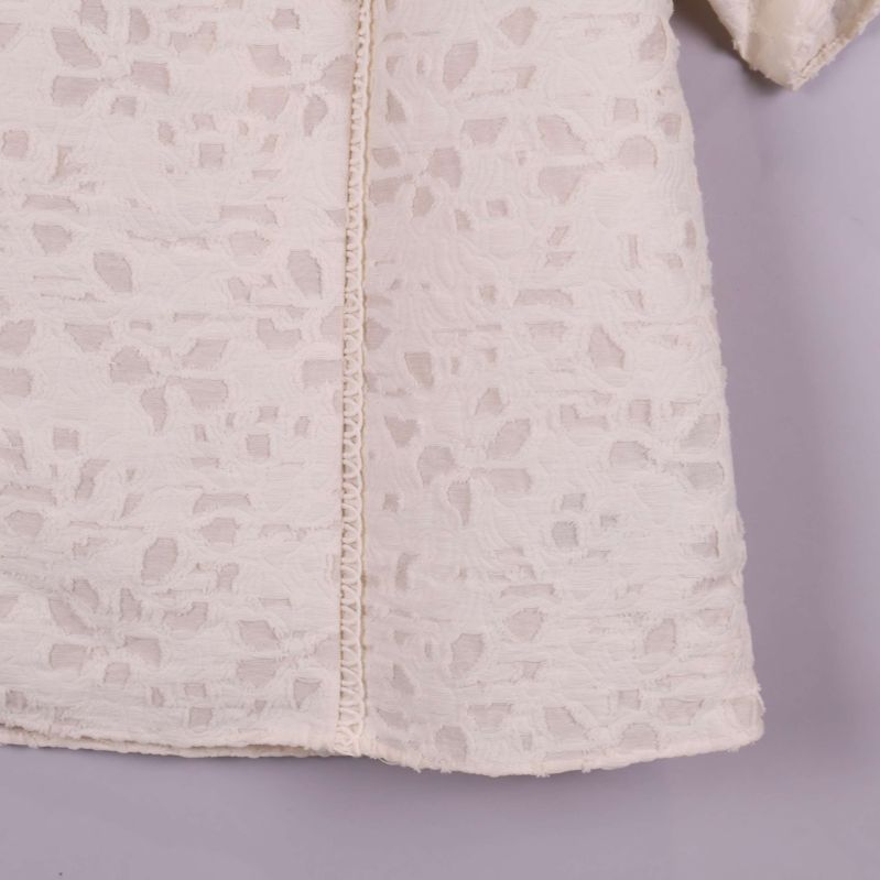 Närbild på tyg med mönstrad struktur och söm