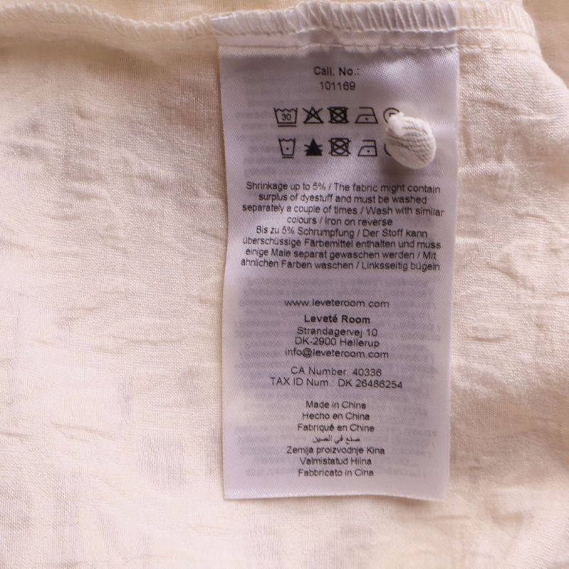 Material- och skötseletikett inuti toppen