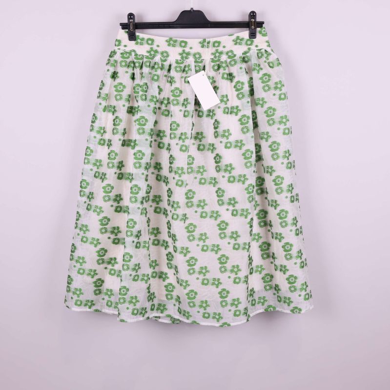 Vit kjol med gröna blommor framifrån på galge