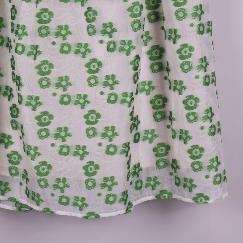 Nederkant på vit kjol med gröna blommor