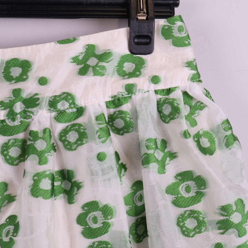 Närbild på midja och tyg med grönt blommönster