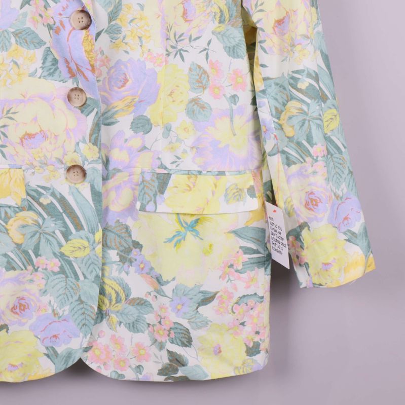 Ficka och knappdetaljer på blommig kavaj i pastelltoner