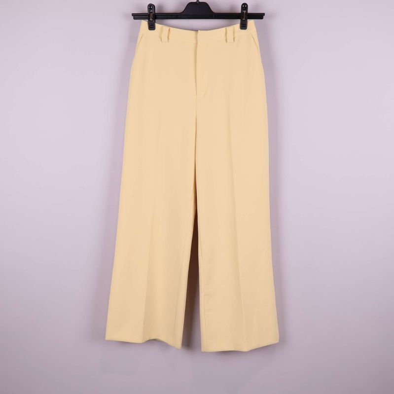 Vida ljusgula byxor upphängda framifrån