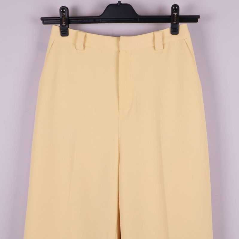 Framstycke av byxan med stängd dragkedja och vida ben