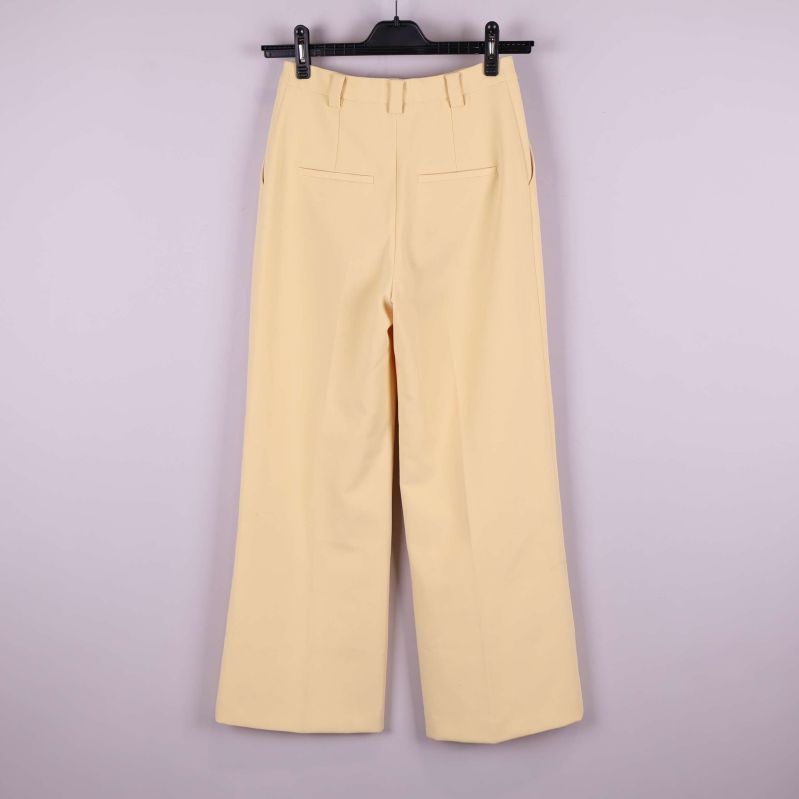 Vida ljusgula byxor visade bakifrån med fickor