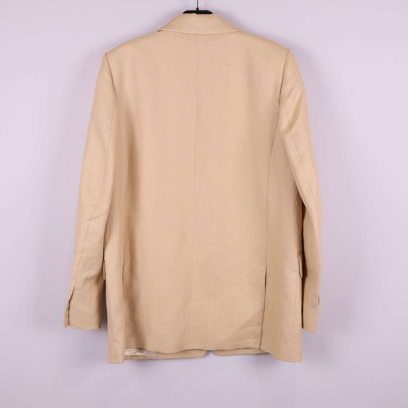 Baksida av beige kavaj på galge