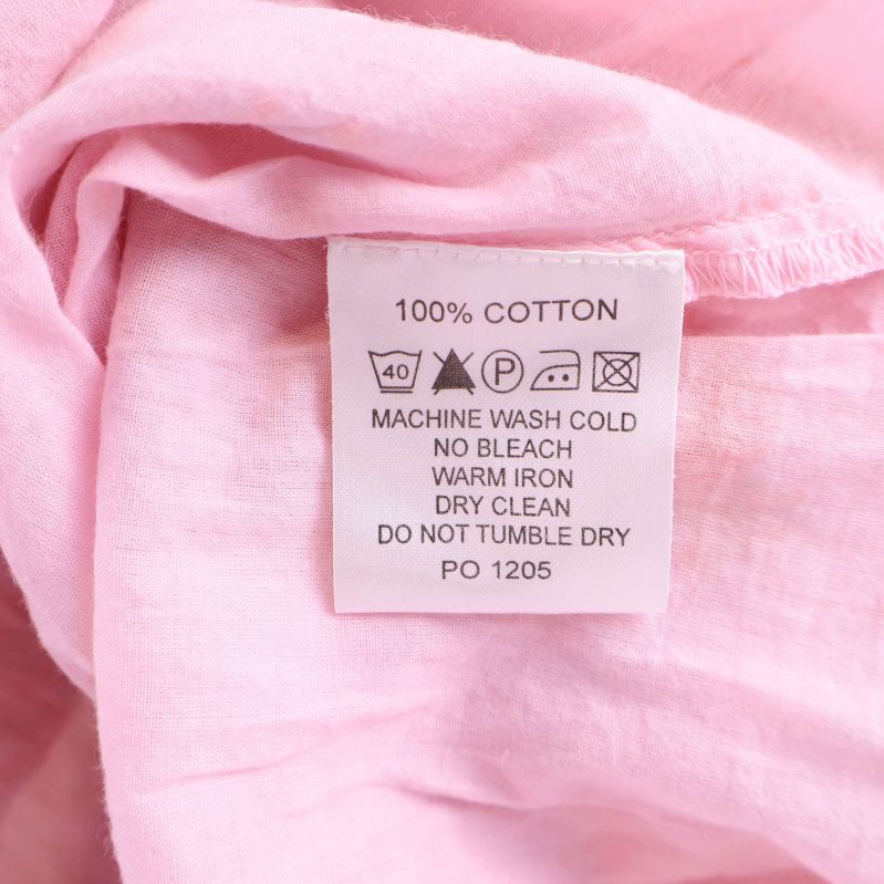 Materialetikett med text 100% Cotton inuti klänningen