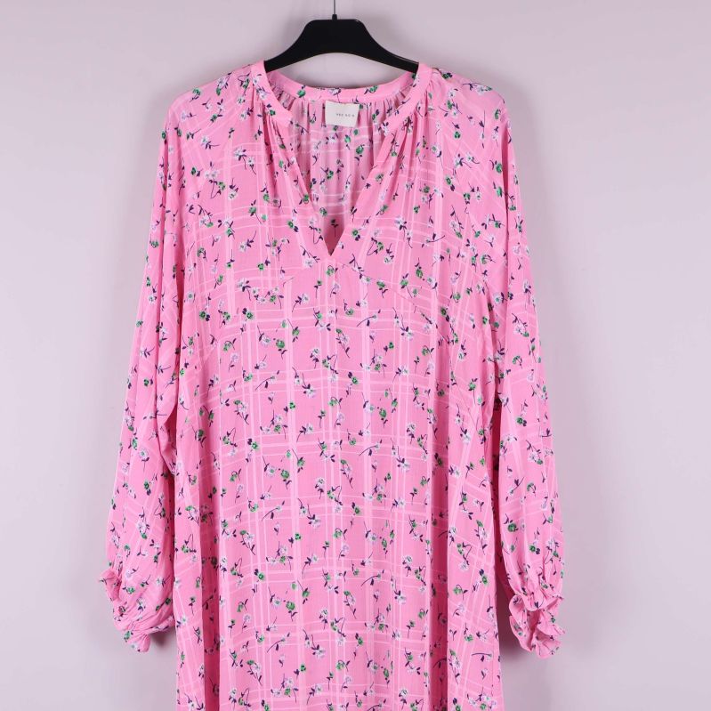 Övre delen av långärmad rosa klänning med mönster