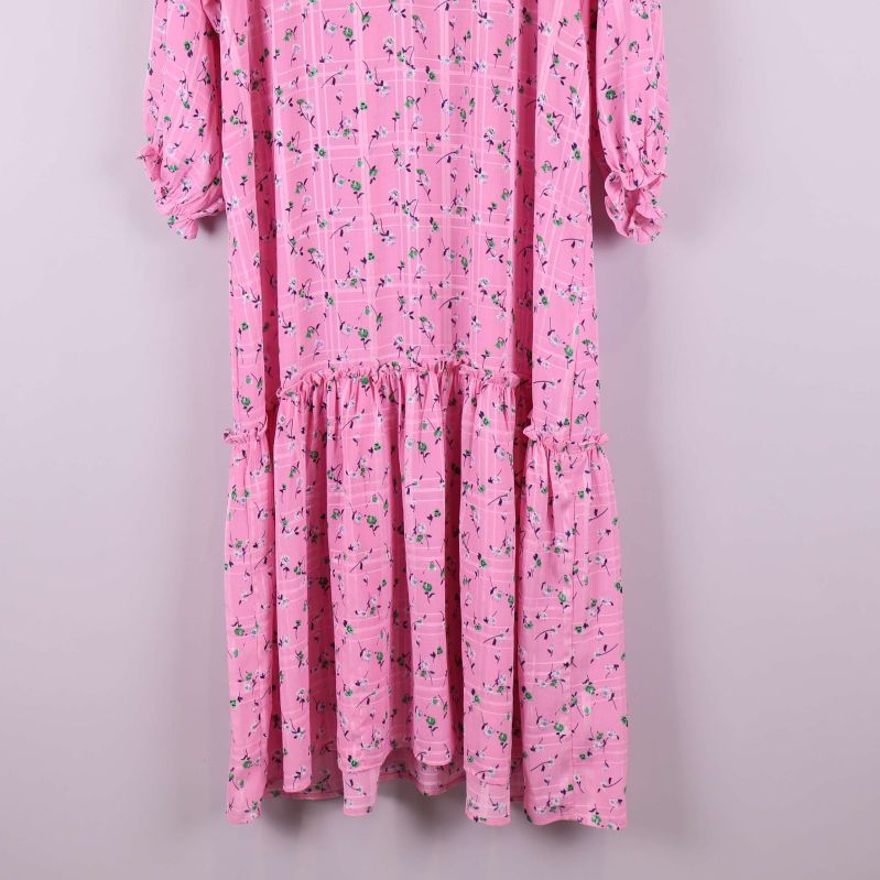 Volangdetalj på nederkant av rosa klänning