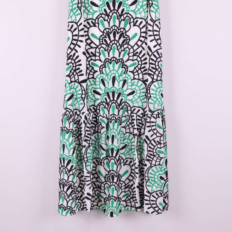 Närbild på nederdelen av klänningen med svartgrönt grafiskt mönster