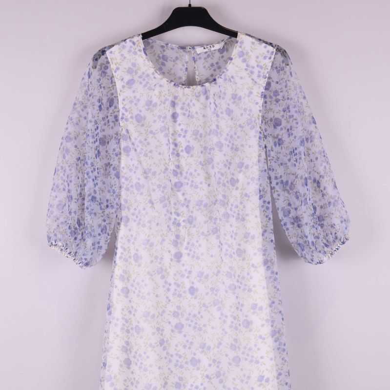 Närbild på puffärm och blommigt tyg