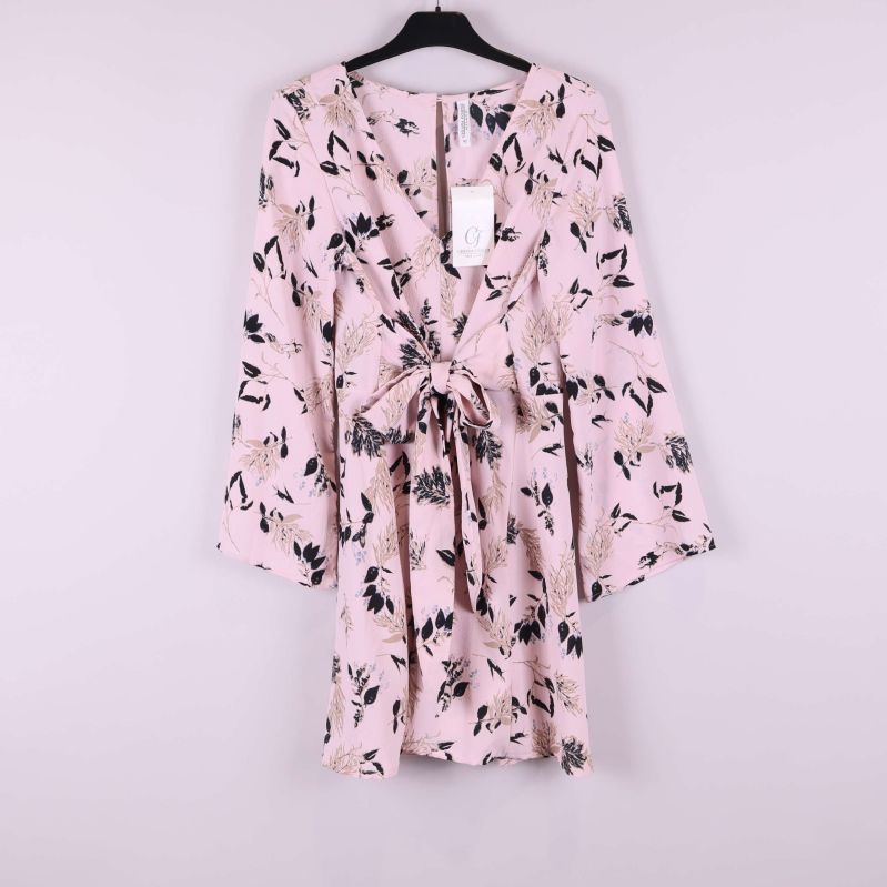 Ljusrosa blommig klänning på galge sedd framifrån