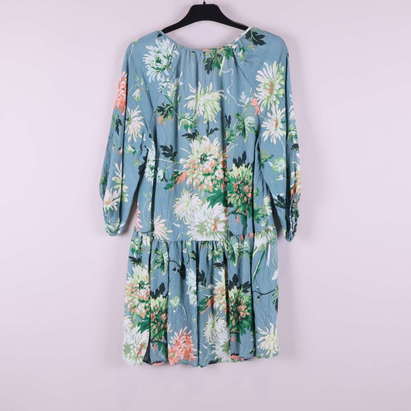 Baksida av blommig klänning med volanger och elastiska ärmar