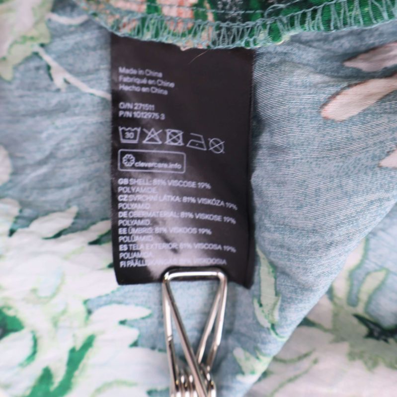 Materialetikett som visar klänningens material och skötselråd