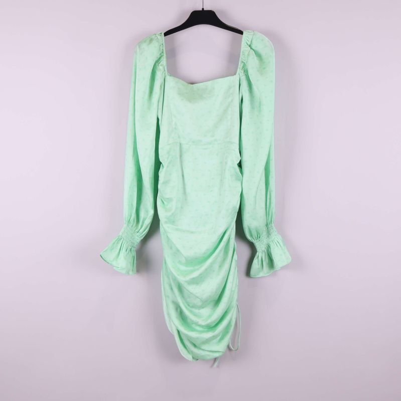 Baksida av mintgrön klänning med utsvängda ärmslut