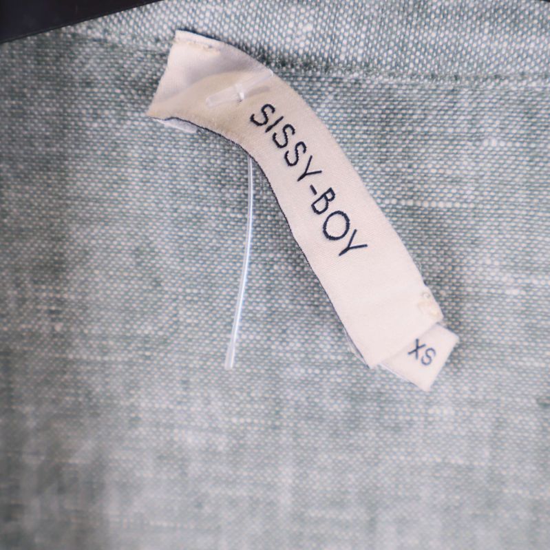 Närbild på etikett med SISSY-BOY och storlek XS
