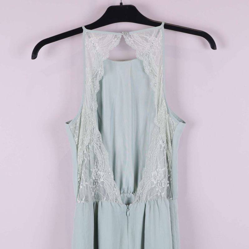 Närbild på spetsdetalj och öppning vid rygg på klänningen