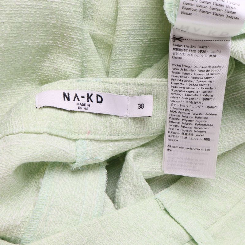 Två etiketter, NA-KD märke och material-tvättlapp på insidan