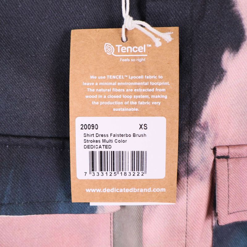 Närbild av pappersetikett med modellnamn och färg, storlek XS