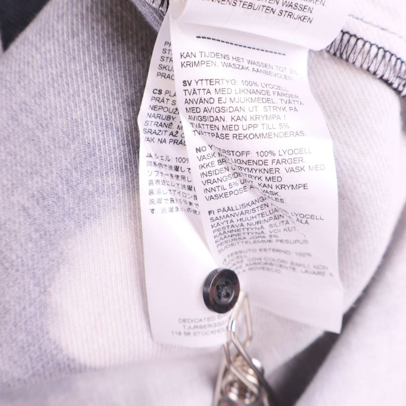 Textiletikett närbild med detaljerad materialinformation och skötselråd