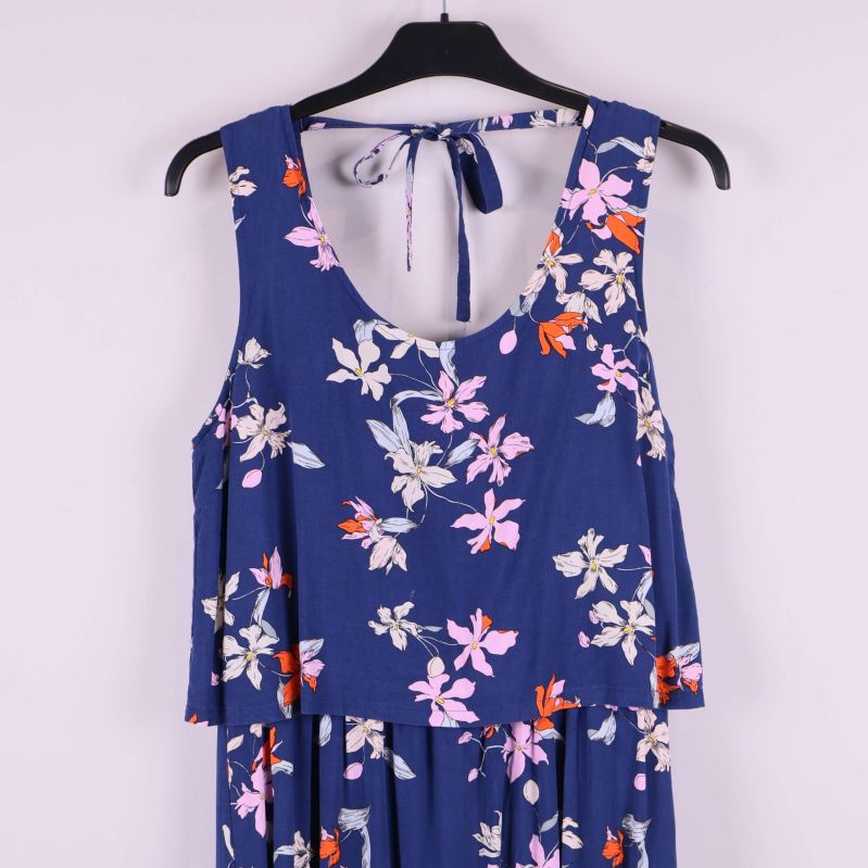 Överkropp på blå klänning med blommigt mönster och knytband