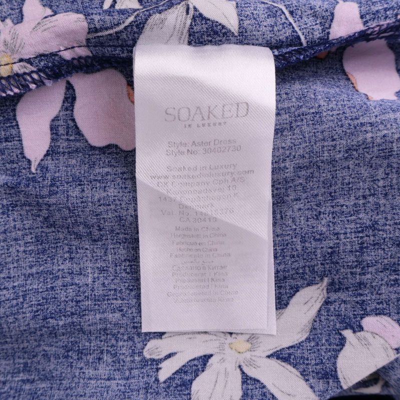 Materialetikett inuti blå blommig klänning