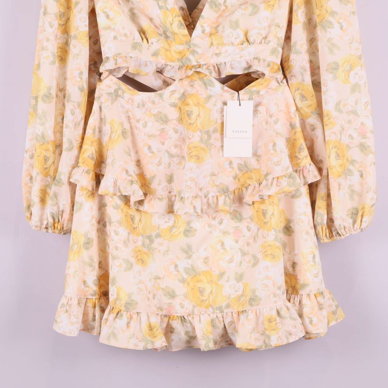 Närbild på blommigt mönster och volang på kjolen