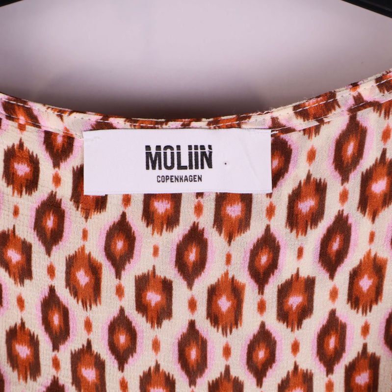 Närbild av MOLIIN-varumärkesetikett inuti klänningen