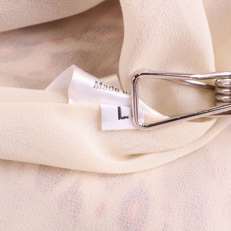 Storlekslapp med bokstaven L fäst i klänningens insida