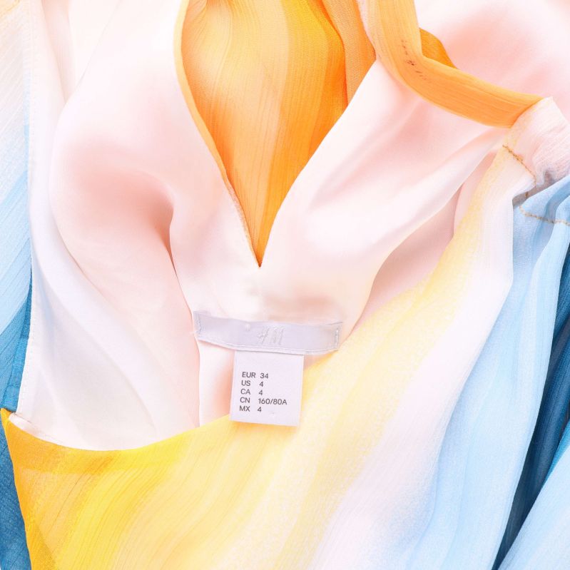 Storleksetikett med EU 34 och H&M logotyp