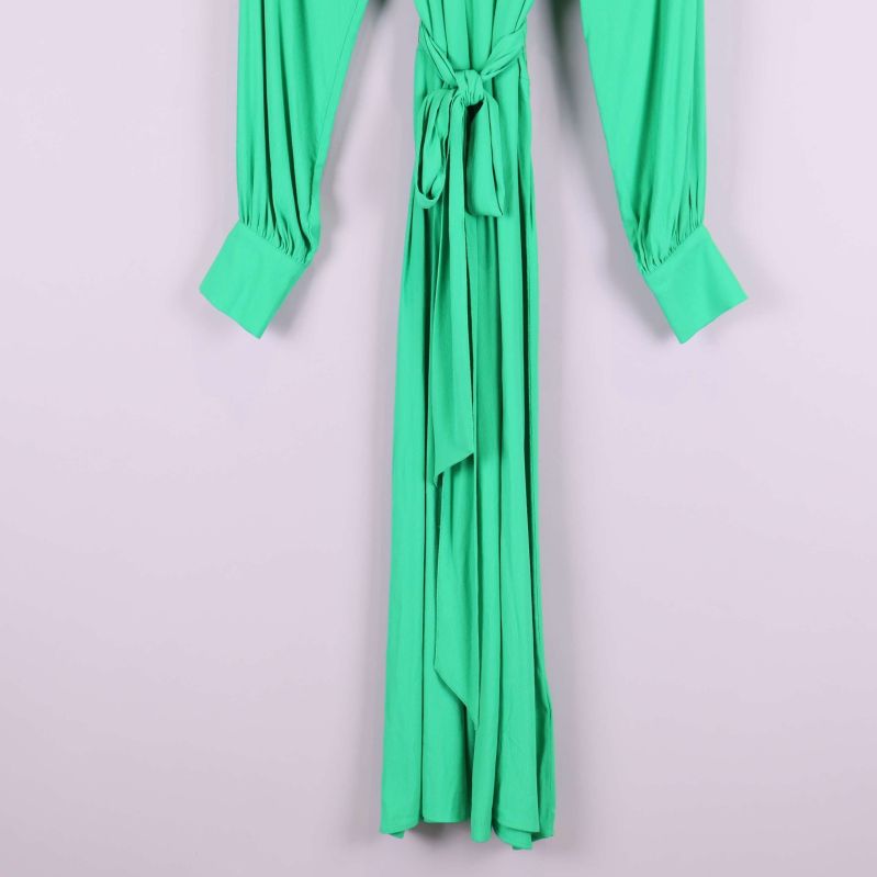 Nedre delen av grön plisserad klänning med midjeknyt