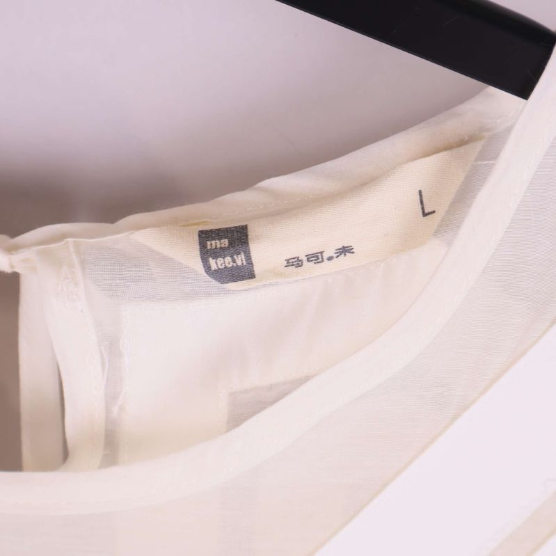 Närbild på klänningens storlekslapp i kragen