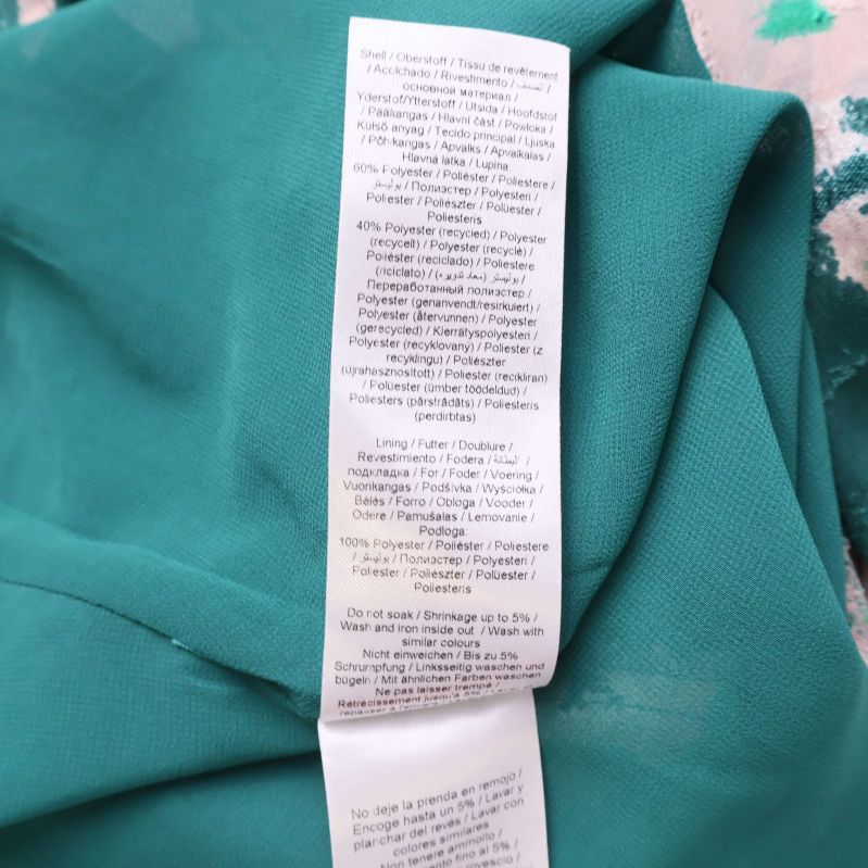 Material- och foderdetaljer på etikett för klänning