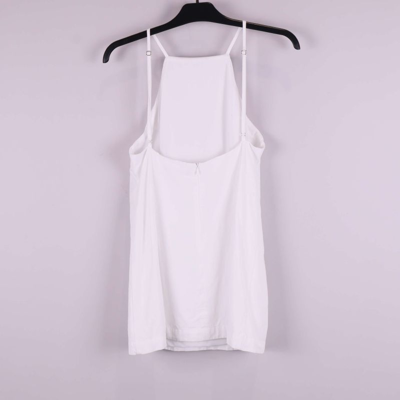 Vit topp med tunna axelband bakifrån på galge