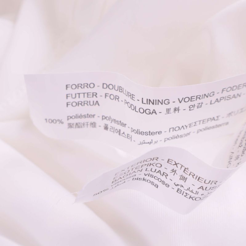 Materialetikett visar 100% polyester i fodret