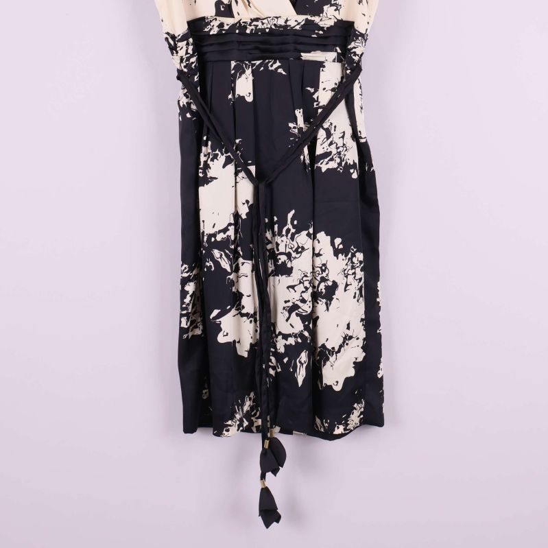 Närbild på midja och knytband med tofs på klänningen