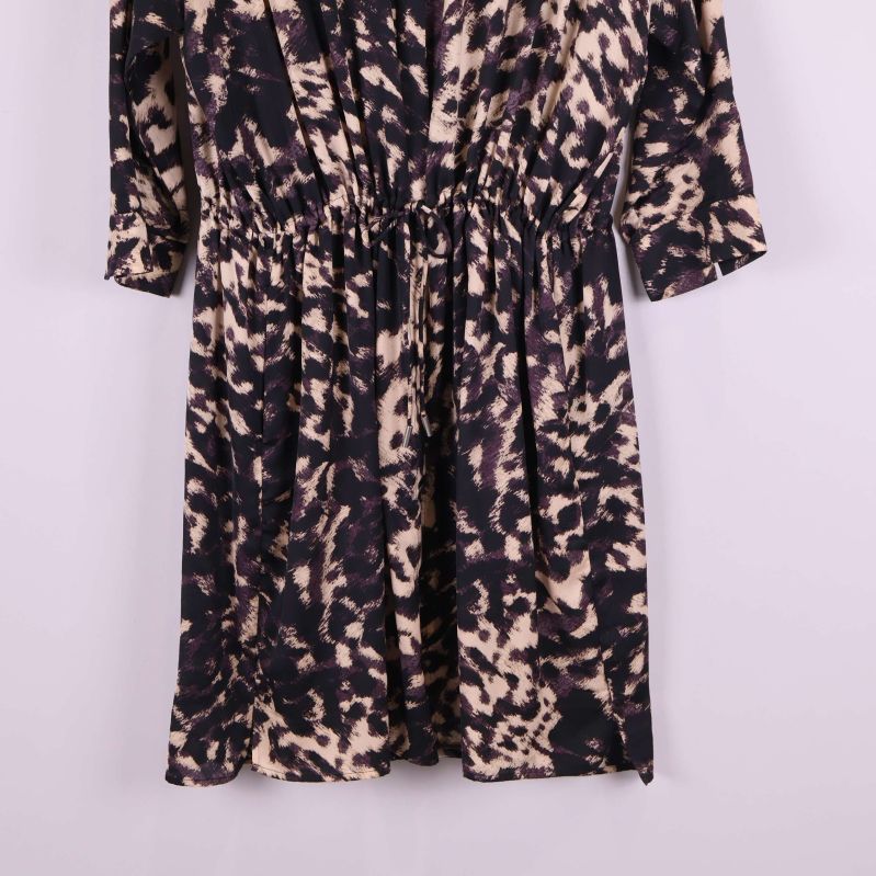 Kjoldetalj på svartbeige mönstrad klänning