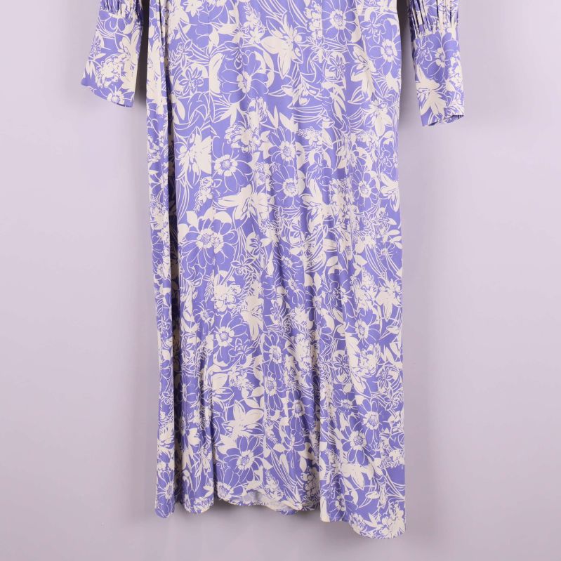 Nederdel av lång blommig lila klänning, närbild