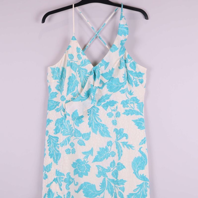 Närbild på klänningens blommiga mönster och korslagda band