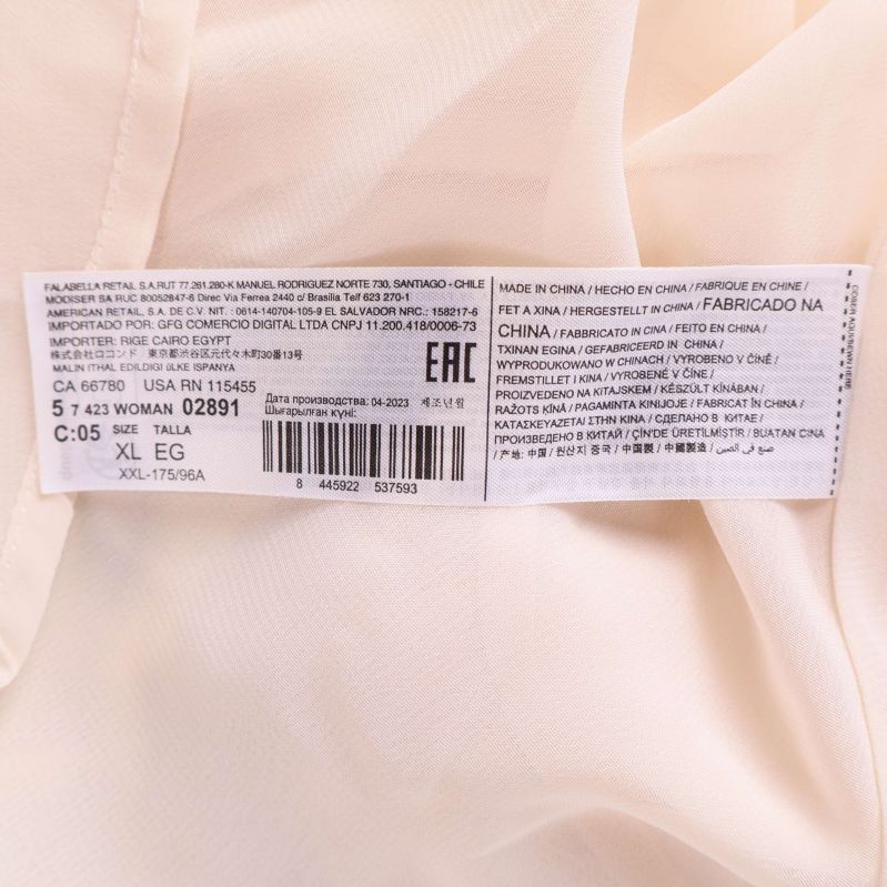 Detaljerad innertagg med materialinformation och tvättråd