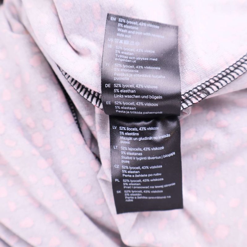 Närbild på materiallapp som visar klänningens sammansättning