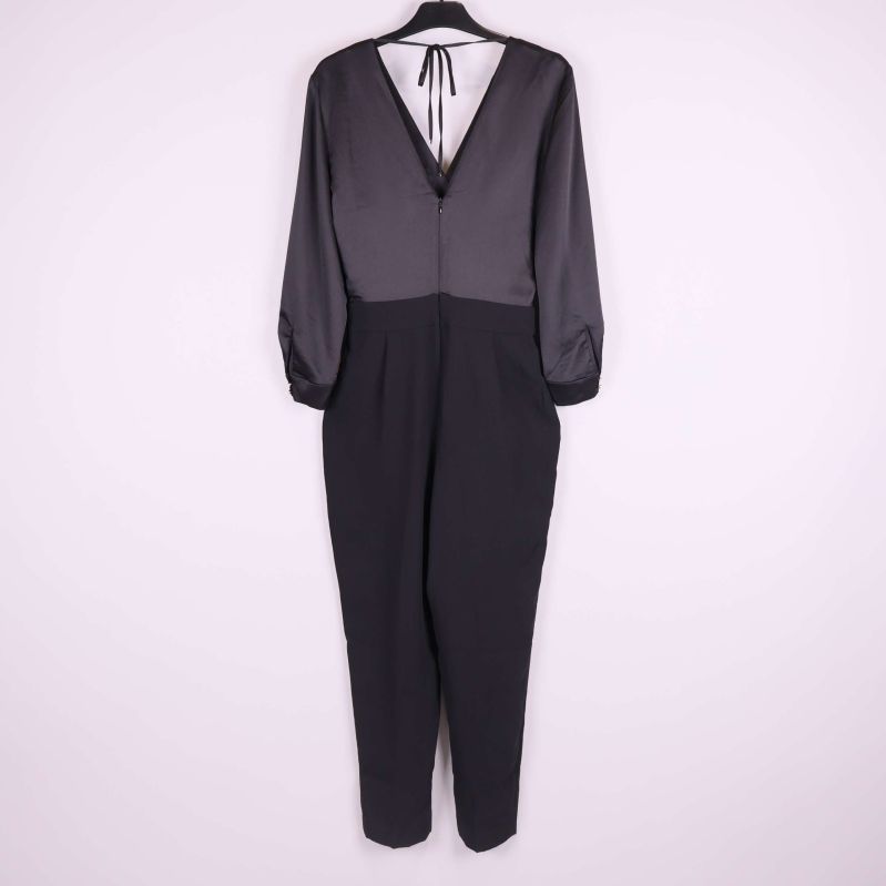 Baksida av svart jumpsuit med v-ringning och knytband