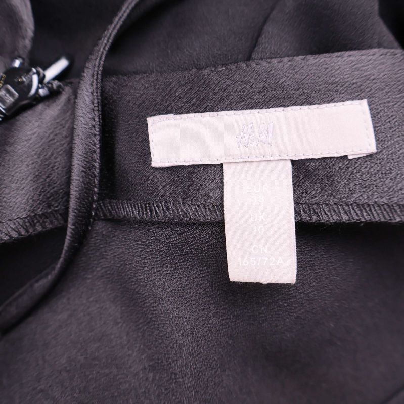 Närbild på H&M etikett och storlekslapp inuti jumpsuit