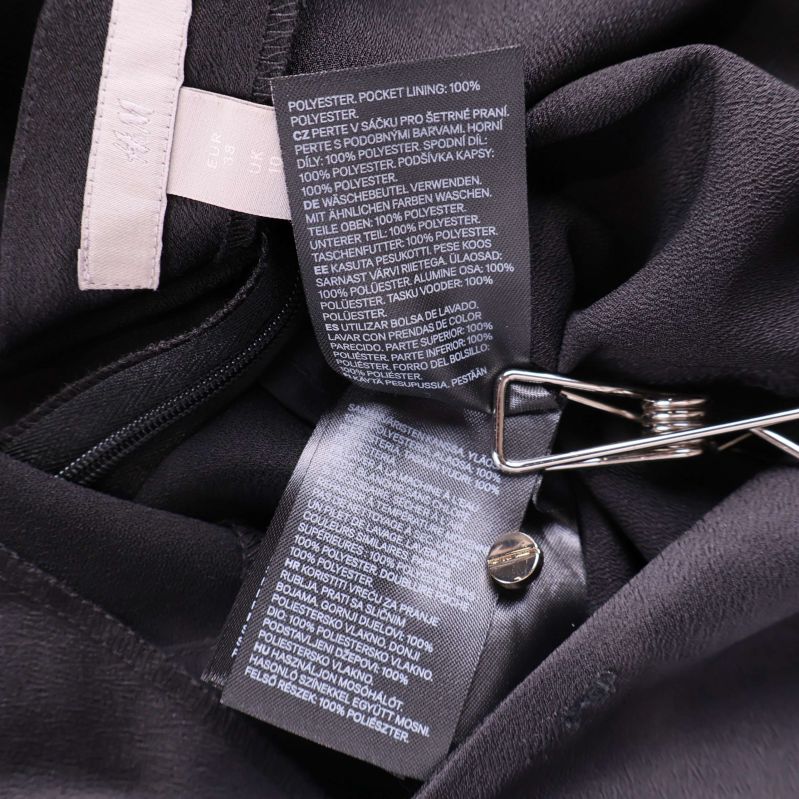 Materialetiketter inuti svart jumpsuit från H&M