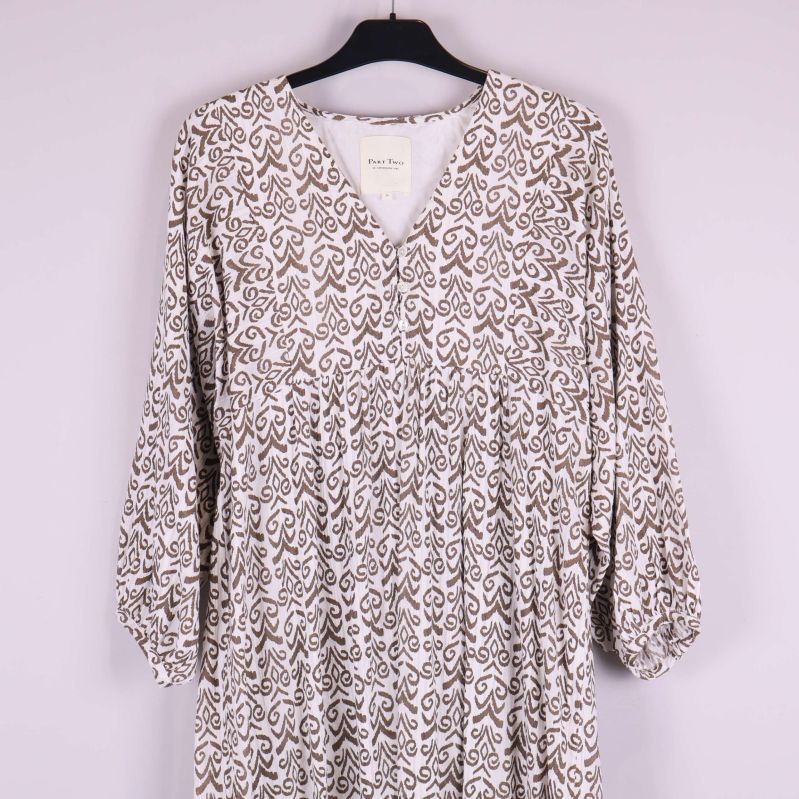 Närbild på klänningens övre del och V-ringning