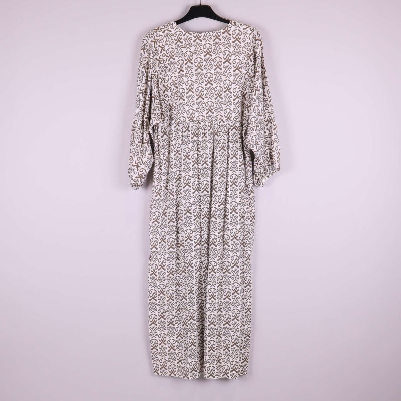 Baksidan av mönstrad långklänning visas på galge