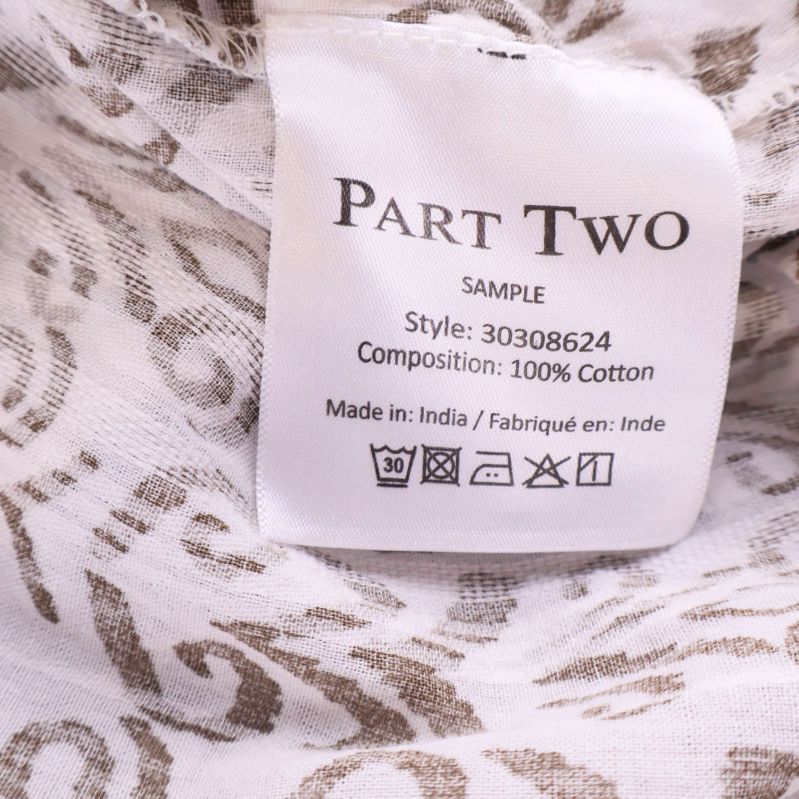 Materialetikett visar 100% bomull på insidan av klänningen