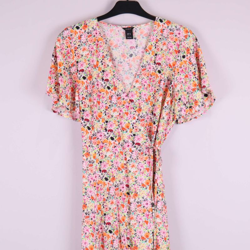 Närbild på överdelen av blommig maxiklänning med v-ringning