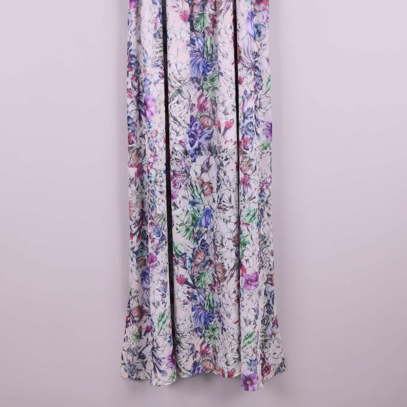 Närbild på nederdelen av blommig långklänning